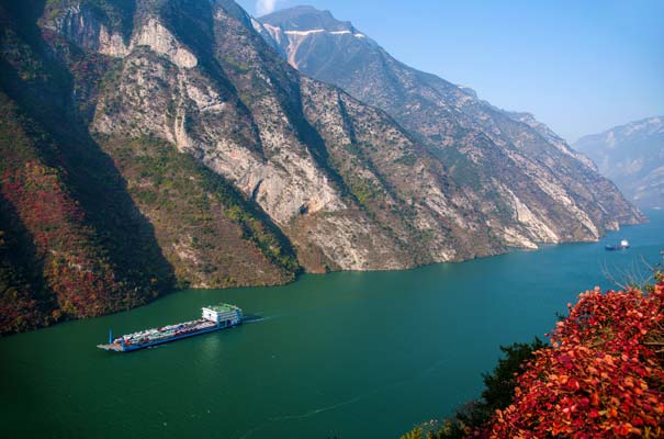 重庆三峡旅游-三峡巫峡段红叶映衬中航行的货运船